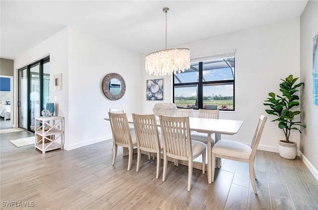 dining room with a notable chandelier, wood finished floors, and baseboards