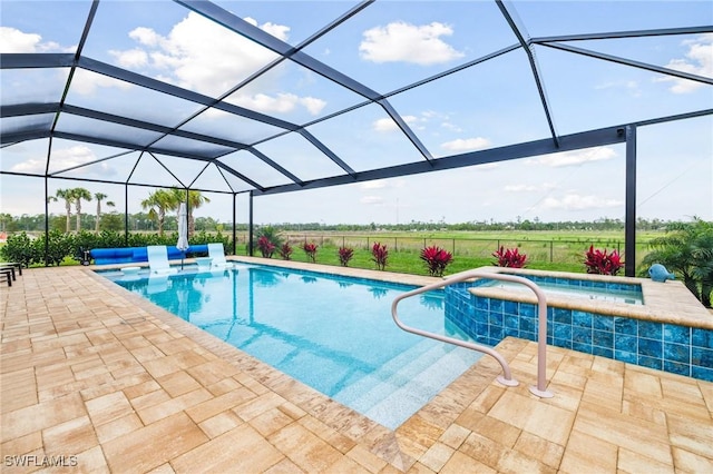 outdoor pool with glass enclosure, a patio, and an in ground hot tub