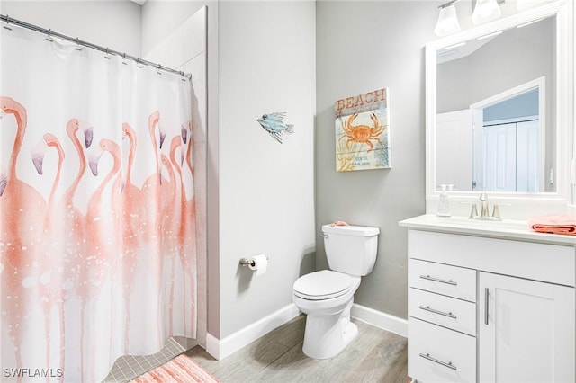 bathroom with baseboards, toilet, wood finished floors, curtained shower, and vanity