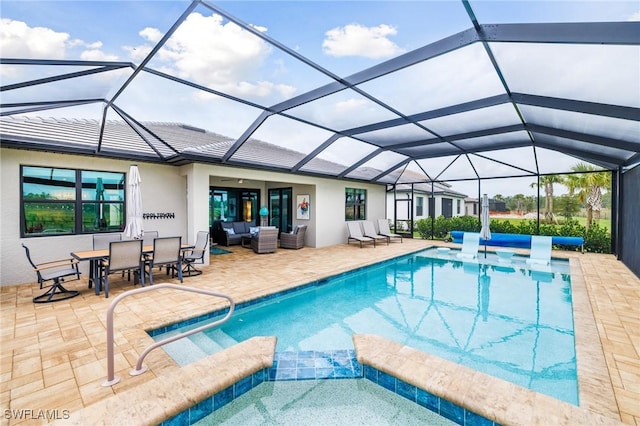 view of pool featuring a lanai, a patio area, a pool with connected hot tub, and an outdoor living space