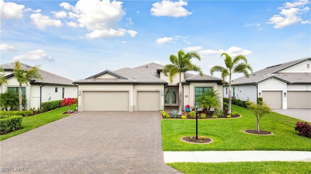 ranch-style house featuring a front yard, decorative driveway, an attached garage, and stucco siding