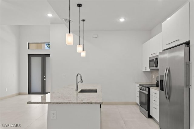 kitchen featuring pendant lighting, appliances with stainless steel finishes, french doors, white cabinetry, and a sink