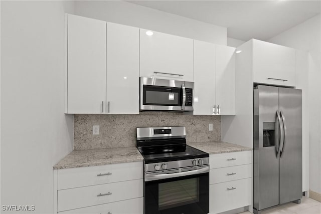 kitchen featuring stainless steel appliances, decorative backsplash, and white cabinetry