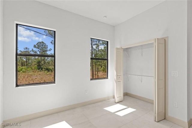 unfurnished bedroom with a closet and baseboards