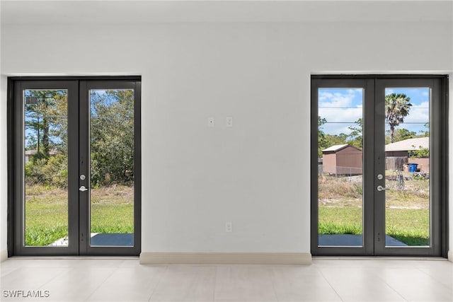 doorway to outside with tile patterned floors, french doors, and baseboards