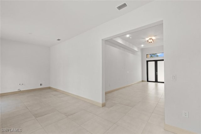 spare room featuring visible vents, french doors, and baseboards