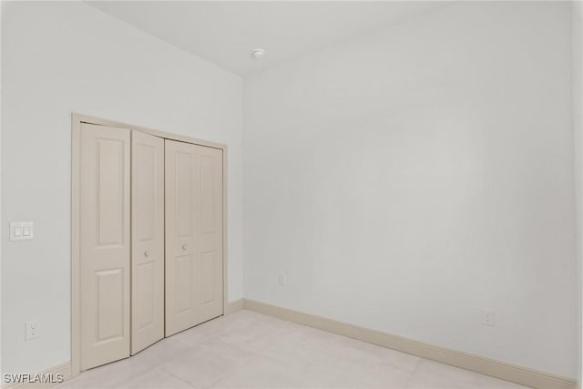 unfurnished bedroom featuring baseboards and a closet