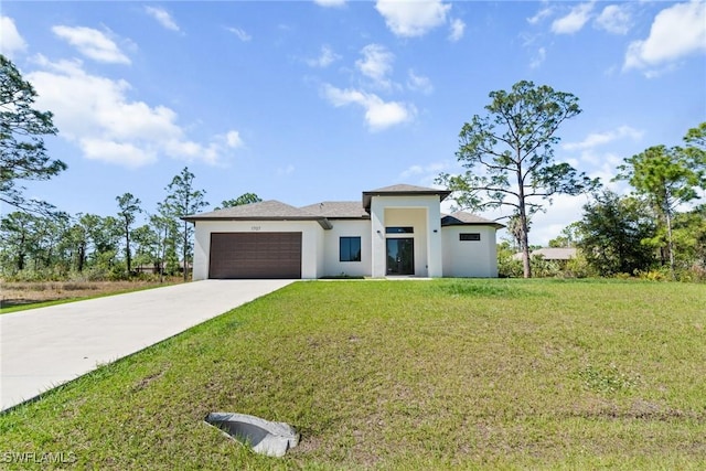 prairie-style house featuring stucco siding, an attached garage, driveway, and a front lawn