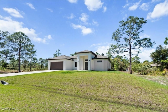 prairie-style home with a front lawn, an attached garage, driveway, and stucco siding