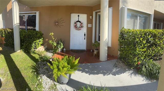 doorway to property featuring stucco siding