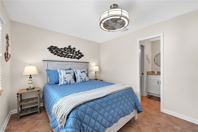 tiled bedroom with visible vents, ensuite bath, and baseboards