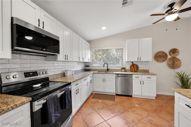 kitchen featuring light tile patterned floors, visible vents, vaulted ceiling, stainless steel appliances, and a sink