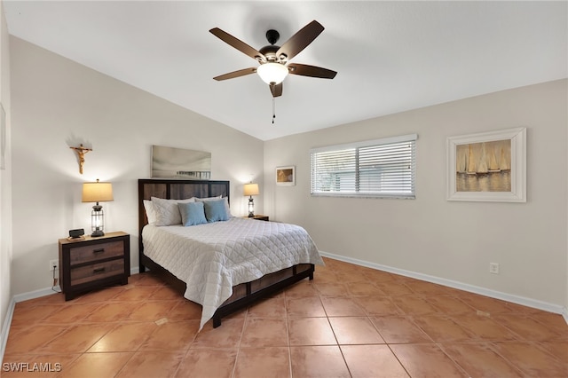 bedroom with a ceiling fan, vaulted ceiling, baseboards, and light tile patterned floors