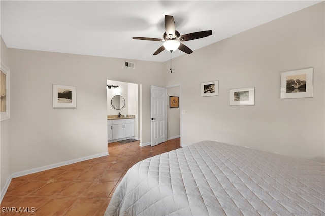 bedroom with light tile patterned floors, visible vents, baseboards, vaulted ceiling, and ensuite bath