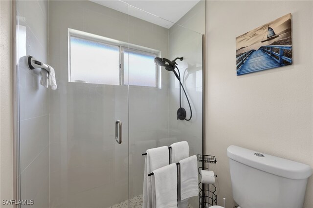 bathroom with a shower stall and toilet