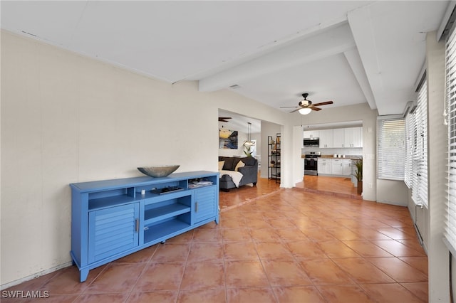 interior space featuring light tile patterned floors, ceiling fan, and beamed ceiling