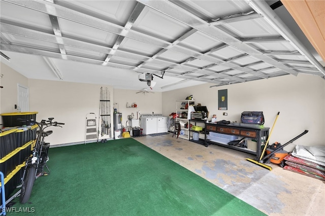 garage featuring electric water heater, electric panel, a garage door opener, a workshop area, and washing machine and clothes dryer