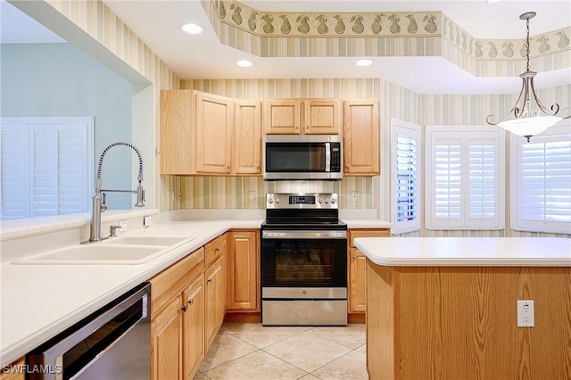 kitchen with wallpapered walls, light brown cabinetry, a sink, light countertops, and appliances with stainless steel finishes