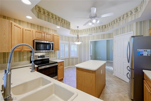 kitchen featuring appliances with stainless steel finishes, wallpapered walls, light tile patterned floors, a center island, and ceiling fan