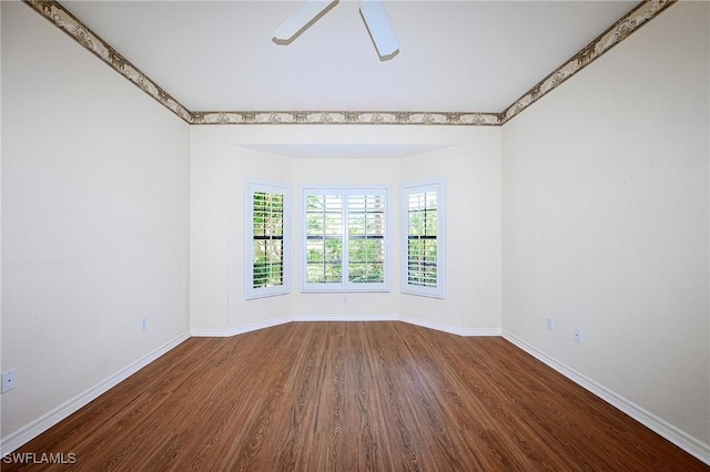 empty room featuring wood finished floors, baseboards, and ceiling fan