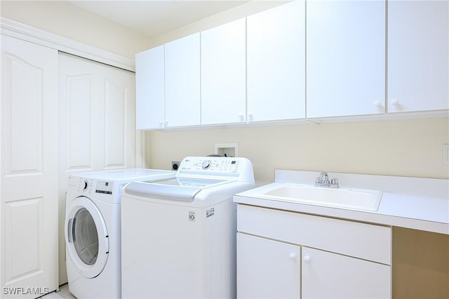 laundry area featuring a sink, cabinet space, and separate washer and dryer