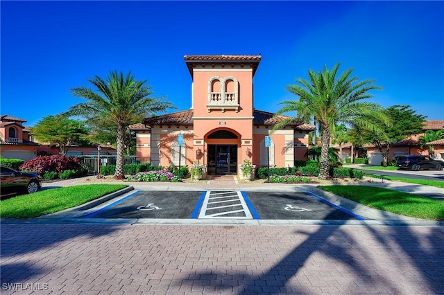 view of property with fence and uncovered parking