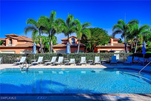 community pool with fence and a patio