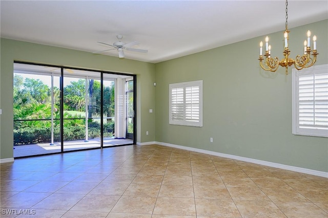 empty room featuring a chandelier, light tile patterned floors, ceiling fan, and baseboards