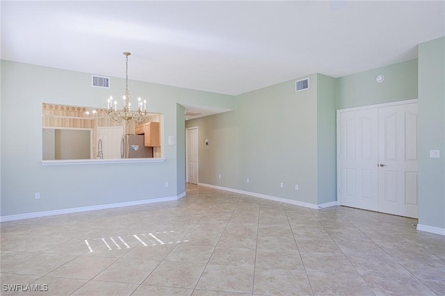 unfurnished room featuring light tile patterned floors, visible vents, baseboards, and an inviting chandelier