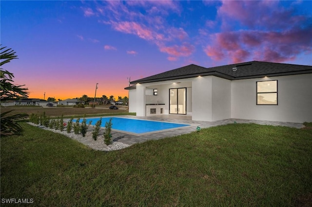 outdoor pool with a lawn and a patio