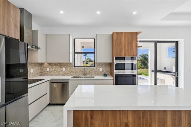 kitchen featuring marble finish floor, tasteful backsplash, appliances with stainless steel finishes, a sink, and modern cabinets