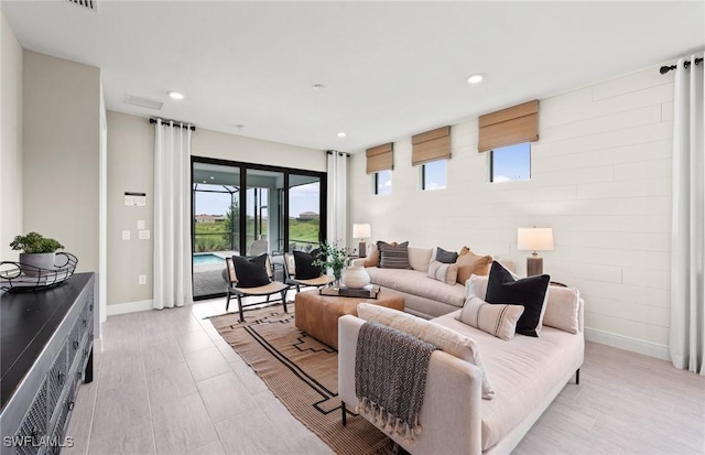 living area featuring baseboards and recessed lighting