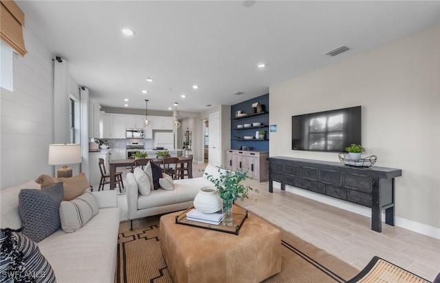 living area with light wood-type flooring, recessed lighting, visible vents, and baseboards