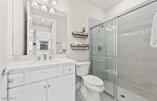 bathroom with a stall shower, vanity, and toilet