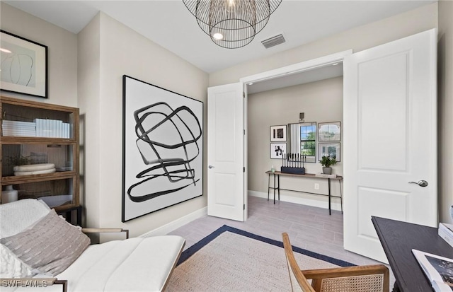 bedroom featuring a chandelier, wood finished floors, visible vents, and baseboards