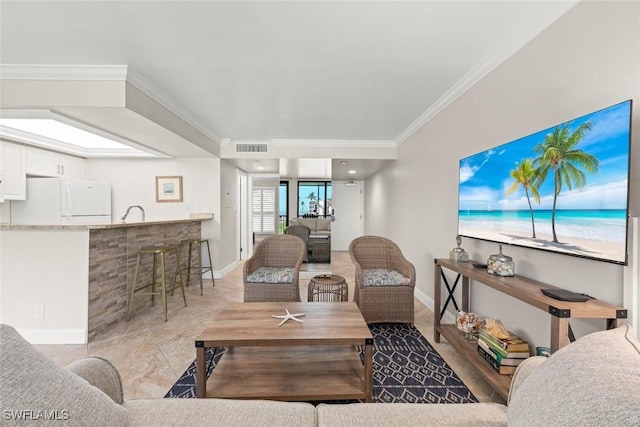 living room with visible vents, baseboards, and crown molding