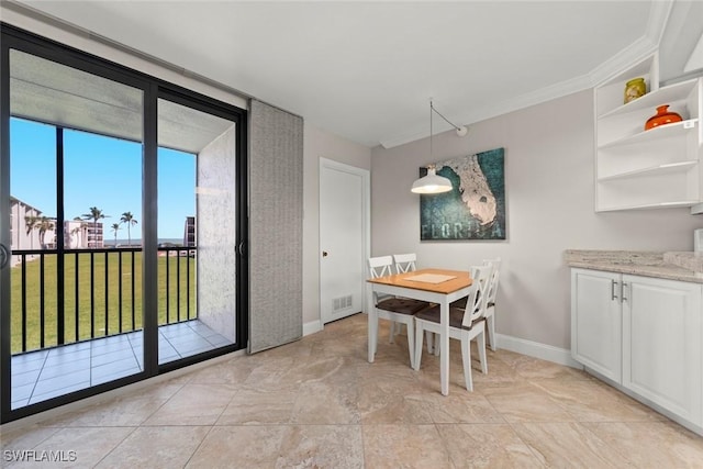 dining room with visible vents, baseboards, ornamental molding, and expansive windows