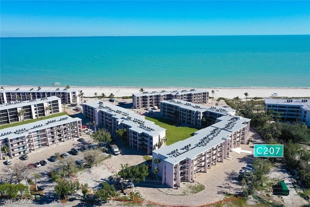 birds eye view of property with a water view and a view of the beach