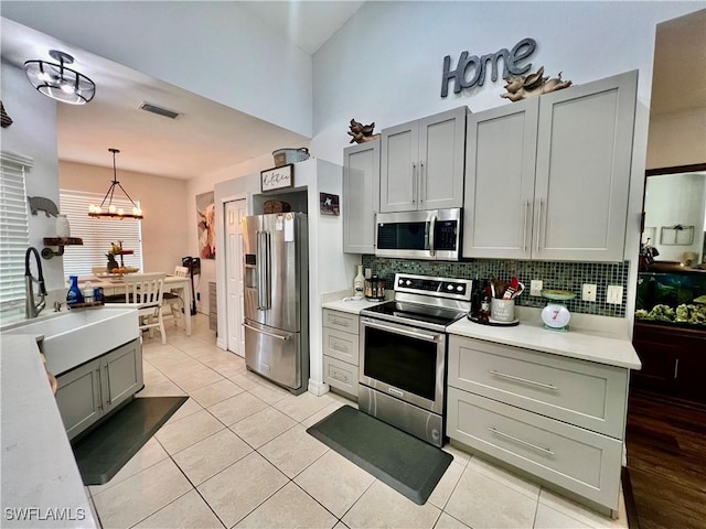 kitchen featuring a sink, decorative backsplash, stainless steel appliances, and light countertops