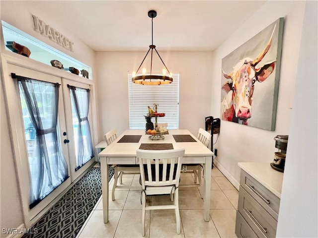 dining area with baseboards, french doors, a notable chandelier, and light tile patterned flooring