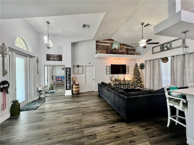 living room featuring high vaulted ceiling, visible vents, dark wood finished floors, and ceiling fan with notable chandelier