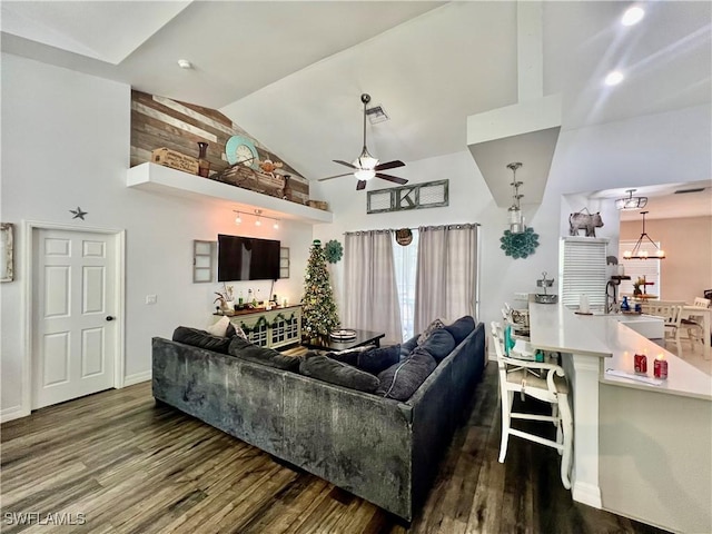 living room with high vaulted ceiling, ceiling fan with notable chandelier, baseboards, and wood finished floors