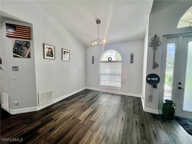 foyer with dark wood-type flooring, visible vents, vaulted ceiling, and baseboards