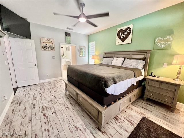 bedroom featuring ceiling fan, ensuite bathroom, visible vents, baseboards, and light wood-style floors