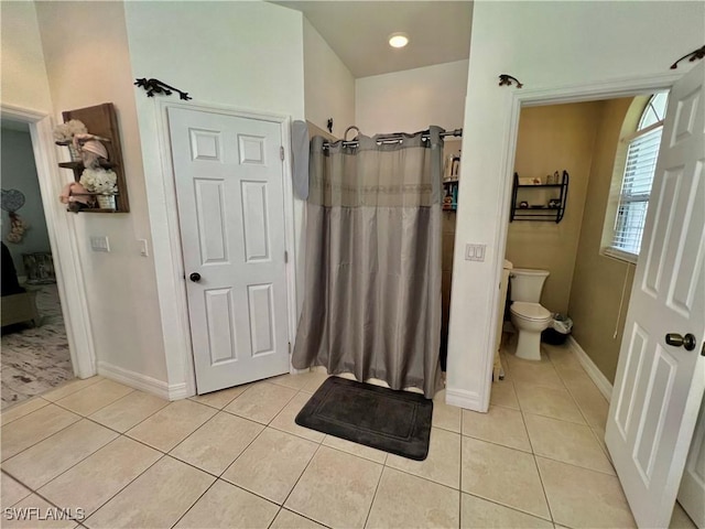 full bath with toilet, a shower with curtain, tile patterned flooring, and baseboards