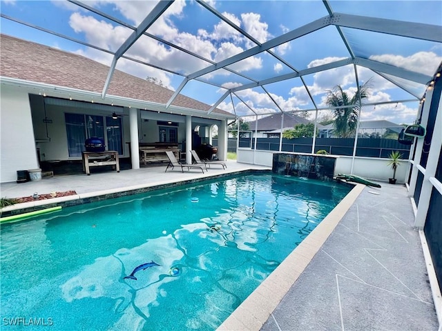 view of pool with a ceiling fan, a fenced in pool, a patio, glass enclosure, and fence