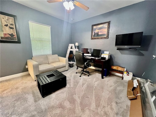 carpeted home office with baseboards and a ceiling fan