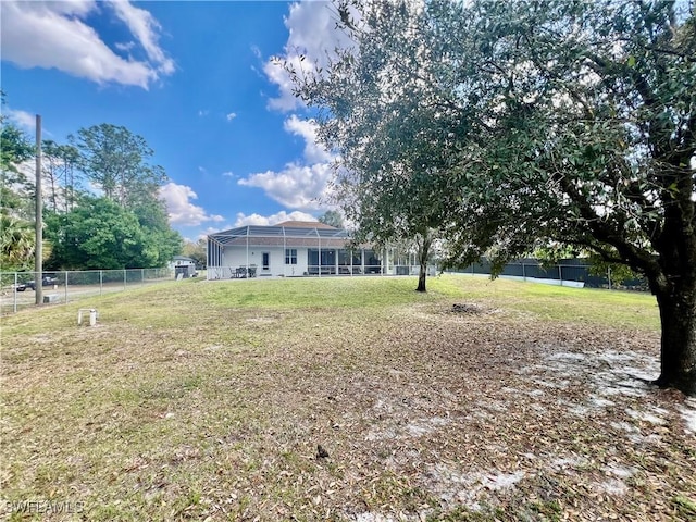 view of yard featuring a lanai and fence