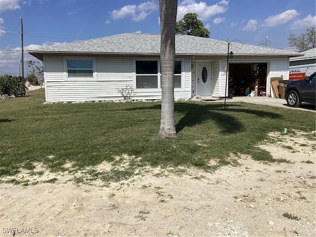 ranch-style home with an attached garage, driveway, a shingled roof, and a front lawn