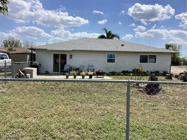 rear view of house featuring fence and a lawn